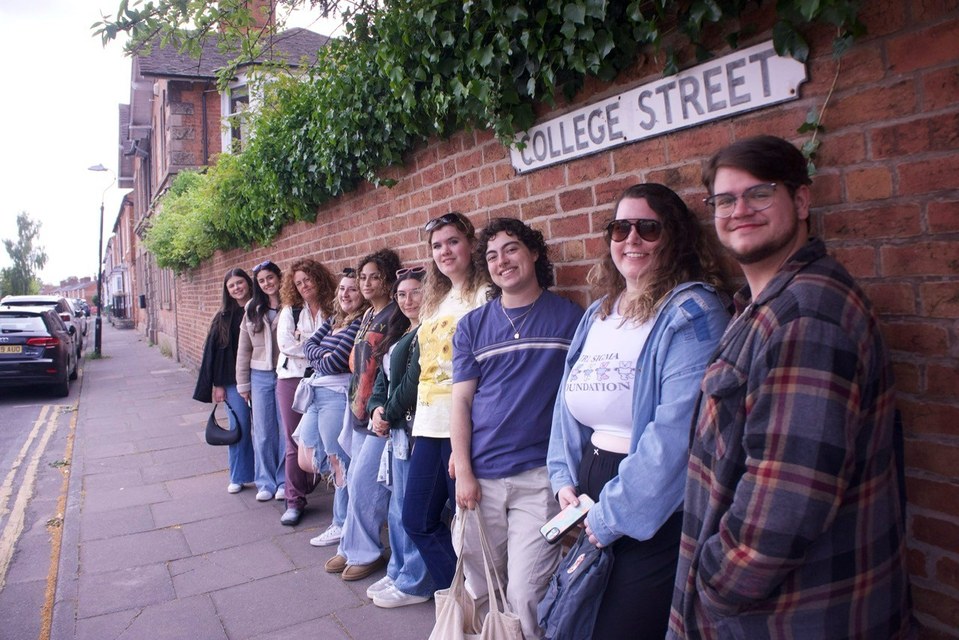 HPU students lined up beneath a College Street sign in Stratford-upon-Avon, England