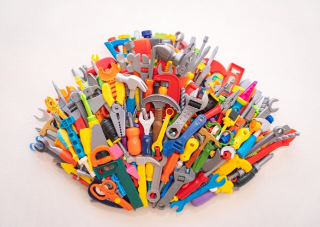 Wall sculpture made of colorful repurposed plastic toy tools
