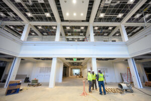 Members of a construction crew stood in the main lobby of the dental school building. An abstract sculpture of a toothbrush will be installed in the lobby.