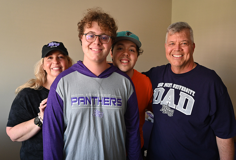 HPU freshman Zander Hertz, second from left, smiled as his mother Jana, brother Josh and father Andrew help him get settled into his new dorm room.