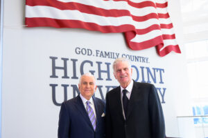 Qubein and Graham stood in front of a U.S. flag display in the concourse of the Nido and Mariana Qubein Arena and Conference Center on HPU’s campus. Underneath the flag, approximately 3,000 pounds of steel originally used to construct the Twin Towers in New York were installed in High Point University letters, along with the letters of “God. Family. Country.”