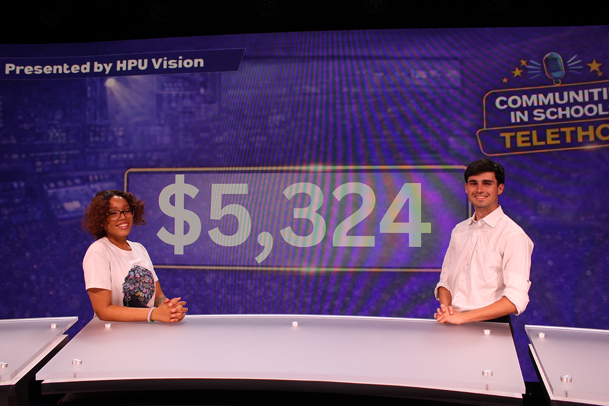 HPU Vision, the university’s student-led news and entertainment network, received donations of $5,324 during the first-ever live telethon. Pictured from left were HPU student Sidney Jones, the telethon’s associate producer and head script writer, and Jack O’Donnell, HPU Vision’s president and a senior majoring in popular culture and media production in front of the final tally. More donations came in after the telethon.