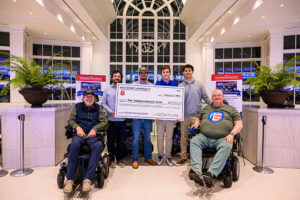 From left are U.S. Navy veteran Jeff Farlow sitting in a Track Chair as Kappa Alpha Order brothers Holden Quinn, Parker Pierce, Keegan Broderick and Max Mody hold a ceremonial check for $104,000 next to Dr. Lewis Scott Oatman, a retired U.S. Air Force technical sergeant. Operation K.A.R.E., a national initiative started by HPU’s Kappa Alpha Order in 2016, raised a record $104,000 last fall to provide Track Chairs for four veterans, including Farlow and Oatman.