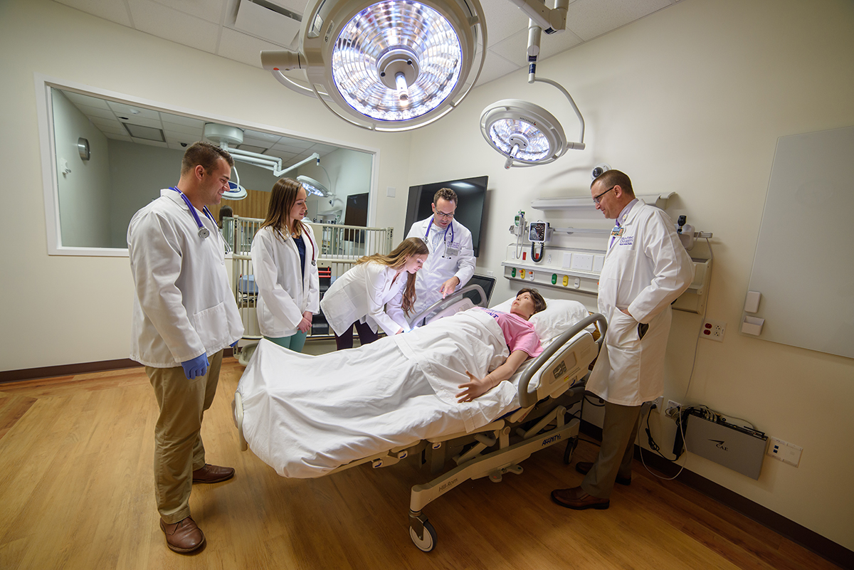 HPU advanced to a larger category in the U.S. News & World Report rankings due to continual growth in graduate degree programs. A group of graduate students and faculty members from HPU’s physician assistant program gathered around a state-of-the-art mannequin inside a simulation lab.