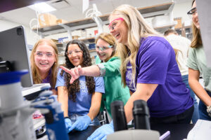 From left, students Chloe Cox and Lillie Wilson smiled as Dr. Meghan Blackledge, associate professor of chemistry and director of HPU’s Natural Sciences Fellows, pointed out antibiotic resistance findings to them and students Maggy Henkle and Izzie Marshall, at right.