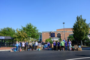 HPU students and staff members, as well as City Transfer and Storage employees, posed for a photo before they started loading a moving truck with supplies for hurricane victims.