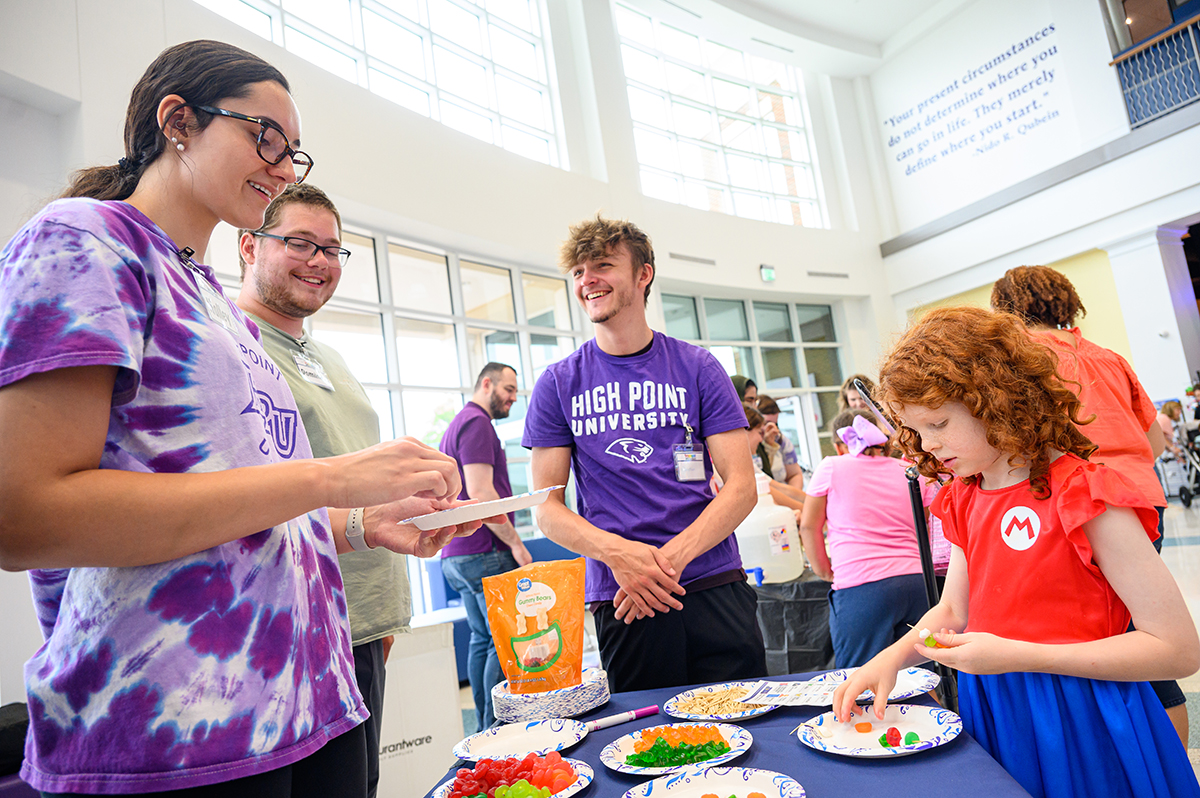 HPU students smiled as they served edible DNA to children like this girl, who stacked her edible DNA in a kabob.