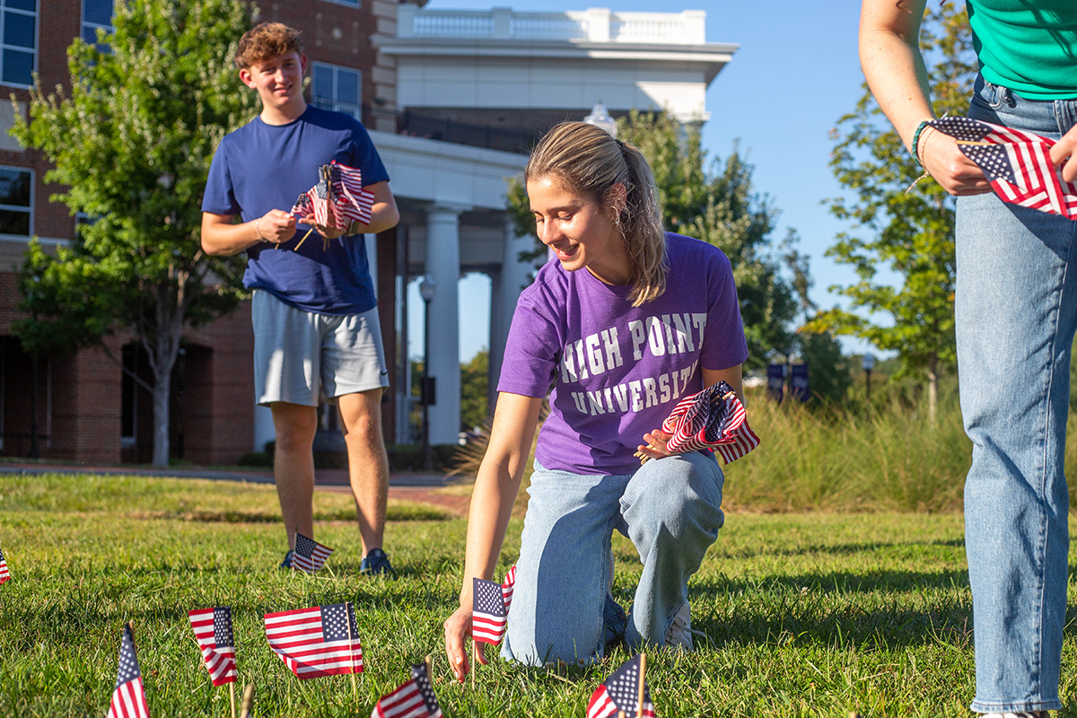 Alexa Klein, a freshman biology major from Baltimore, Maryland, planted American flags as Alex Muravski, a freshman mechatronics engineering major from Tulsa, Oklahoma, prepared to plant more flags.