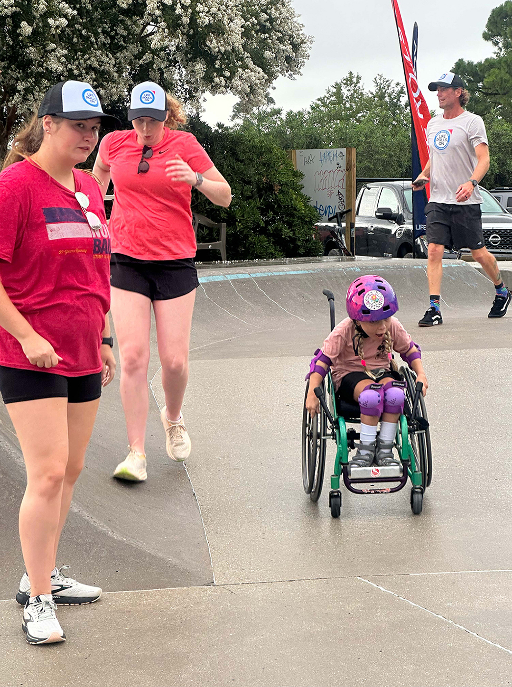 Physical therapy students Sarah Tiller, left, and Lexi Berry with athlete Ellie Wilson at the Aug. 4 adaptive skating event with Kevin Murphy, organizer and founder of Ocean Cure, shown in the background.