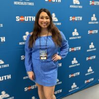 Reagan Smith standing in front of a blue background that says Big South Conference on it.