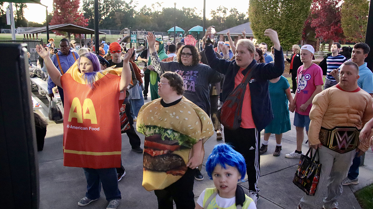 Community members danced to the song “Y.M.C.A.” by the Village People during the Special Populations Halloween Dance and Trunk or Treat at the Miracle League of High Point Field.