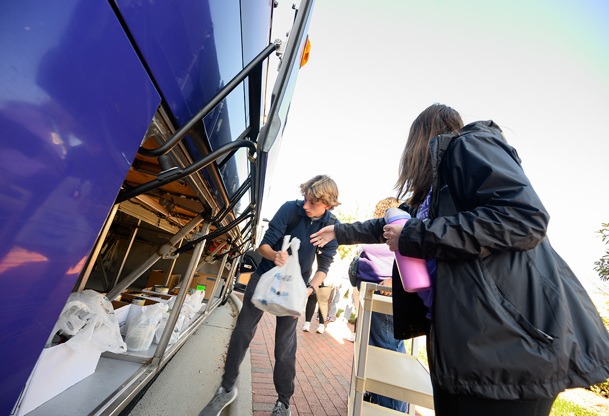 Ben Schipul, a freshman health and physical education major, placed a bag of food in an HPU bus to deliver it to the OOGTP warehouse.