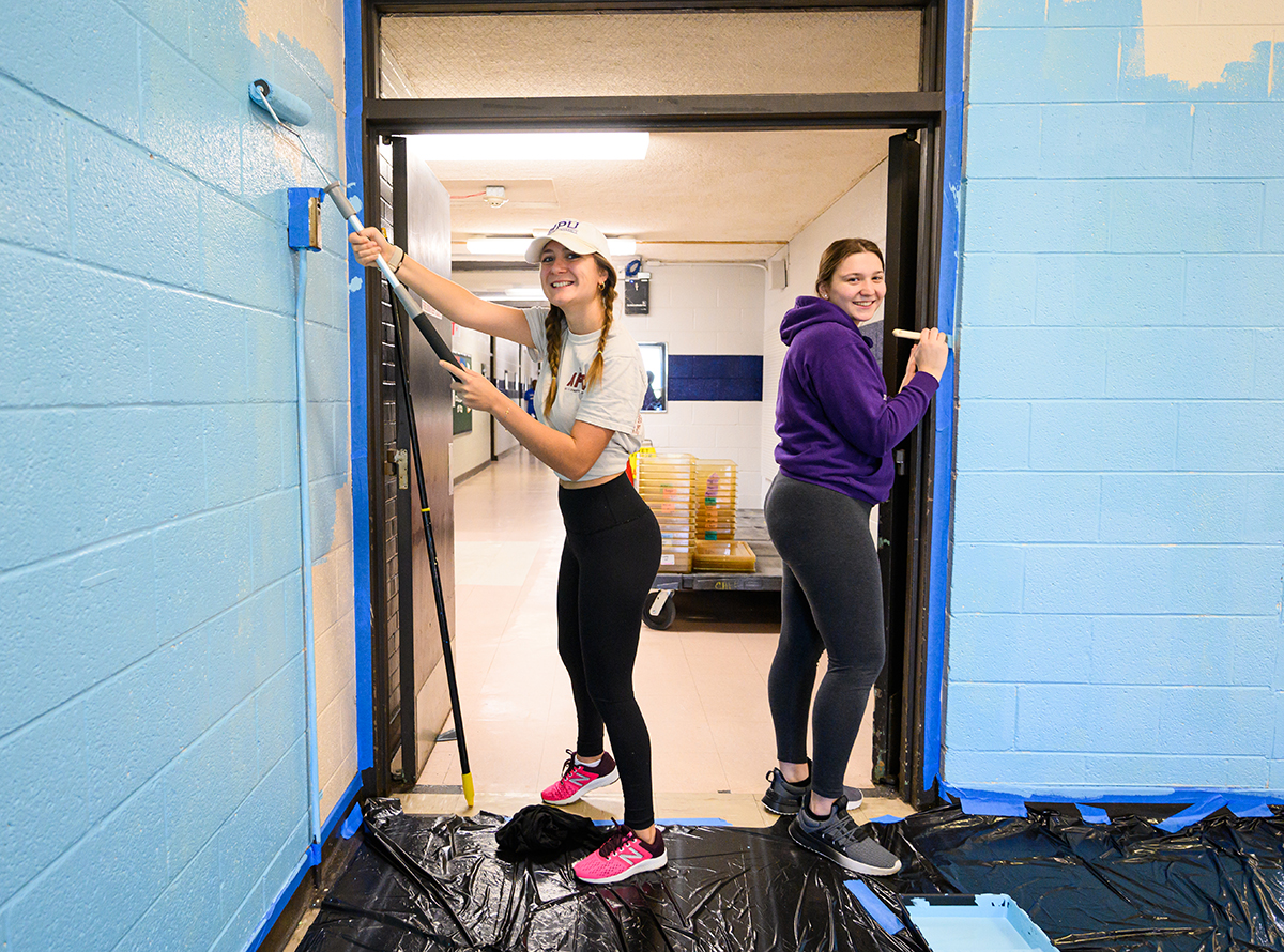 Students smiled as they painted the cafeteria at Oak View Elementary School. 