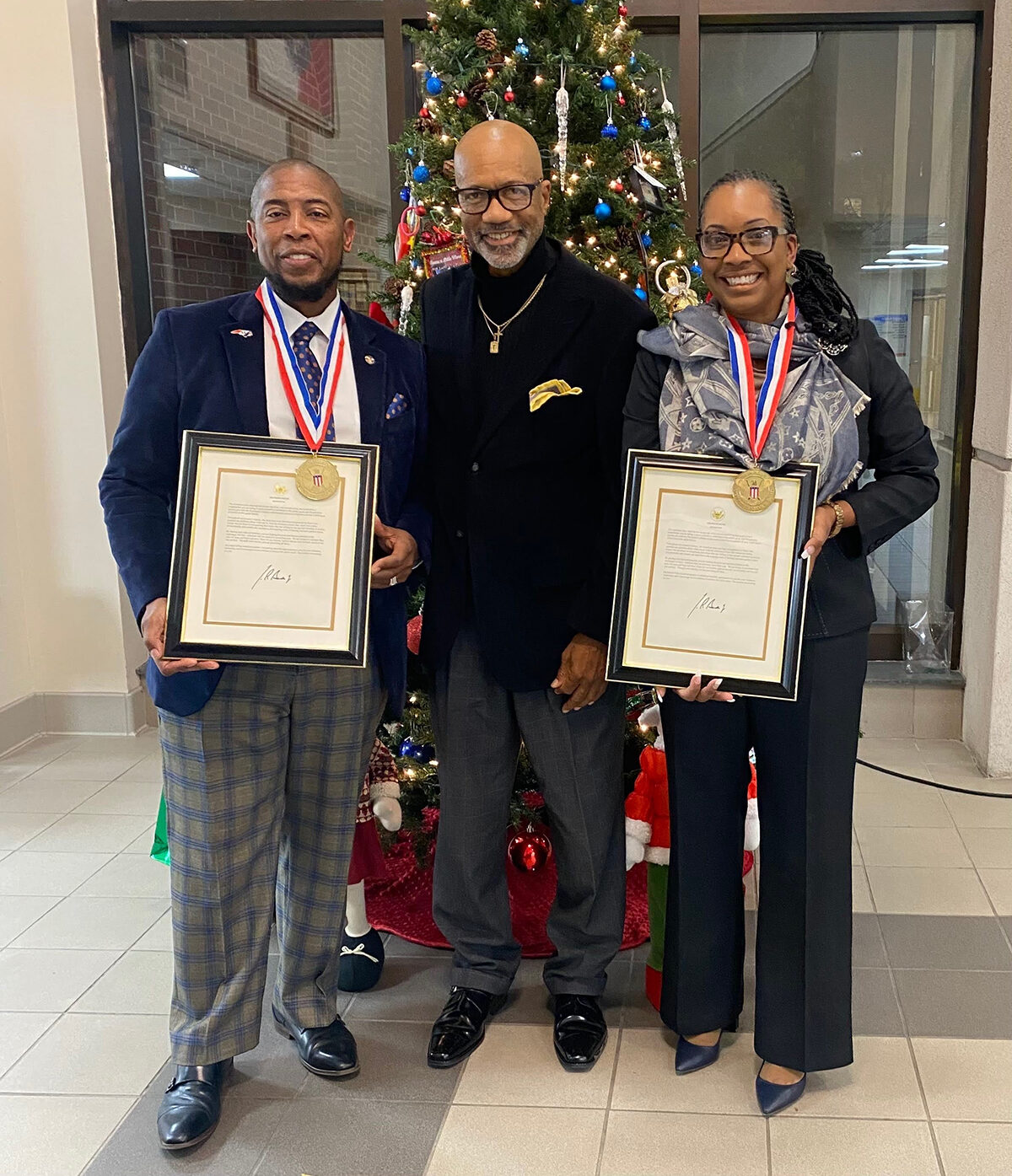Dr. A. Bernard Jones, left, and his wife Amichia Gainey-Jones, an HPU Master of healthcare administration student, received the Presidential Lifetime Achievement Award for their years of community service. They are pictured with Troy Williams, president of Political Consultant Professionals, after receiving their awards at the Fayetteville City Council meeting in Fayetteville, North Carolina. 