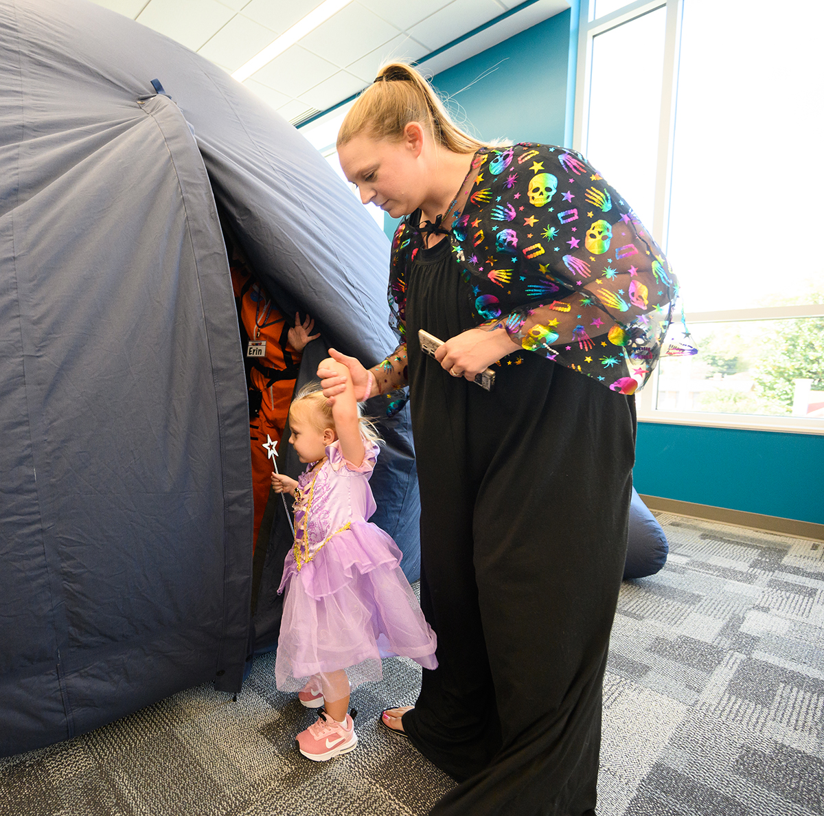 A mother held a young girl’s hand as they entered the Culp Planetarium’s inflatable mobile planetarium show last fall. 