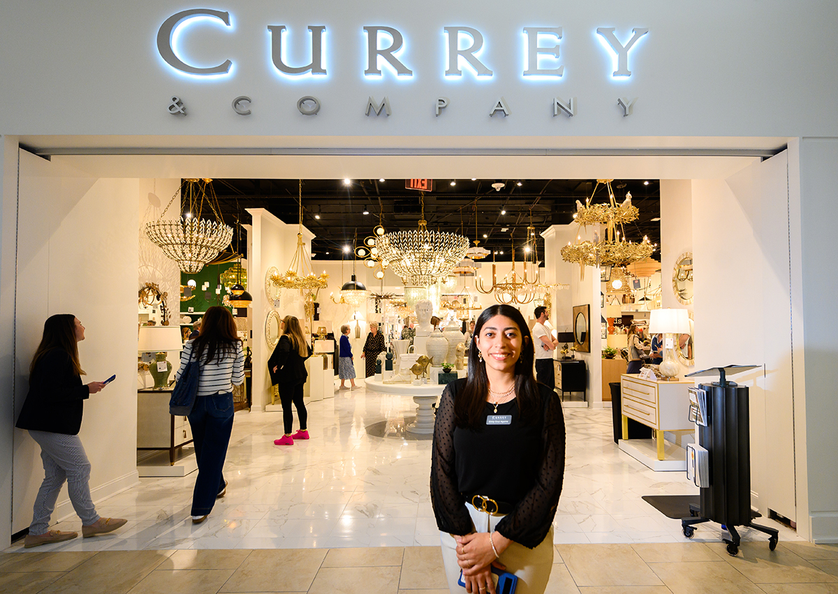 Emily Cruz Aguirre, a sophomore interior design major, scanned badges and greeted guests at the Currey & Company showroom.