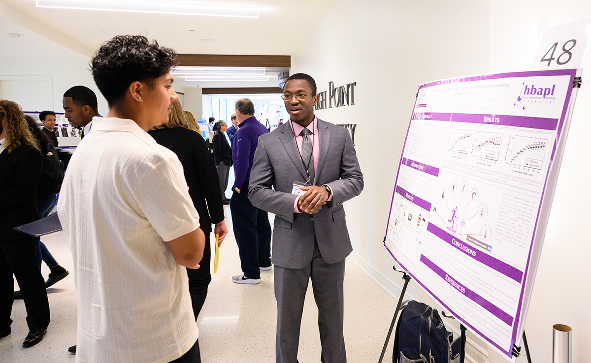 A student listened as Yaw Korankyi, a sophomore pre-pharmacy major from Jamestown, North Carolina, described his research on perceptions of dietary berberine supplementation during exercise-related heat stress.