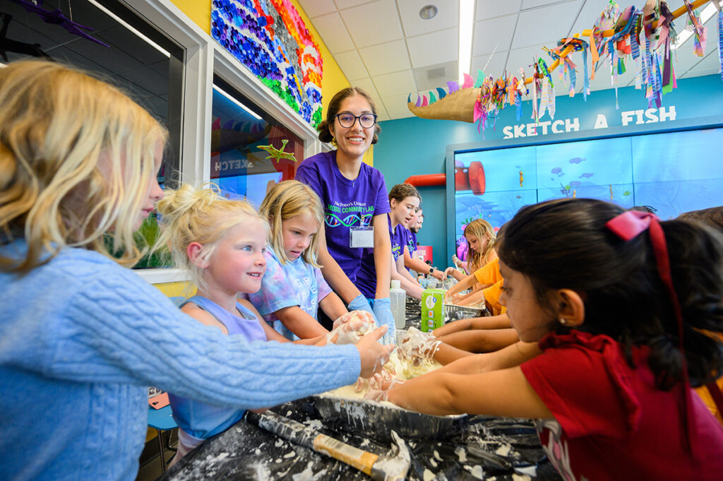 HPU student Aubry Fessler smiled as girls mixed goo with oobleck, a non-Newtonian fluid.