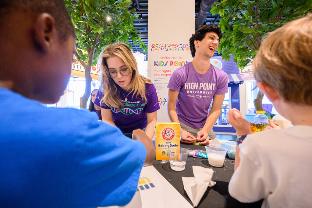 Sophomore biology majors Jordan Havert, left, and Tyler Janick watched children’s excitement build as they used litmus strips to test the acid level of common foods.