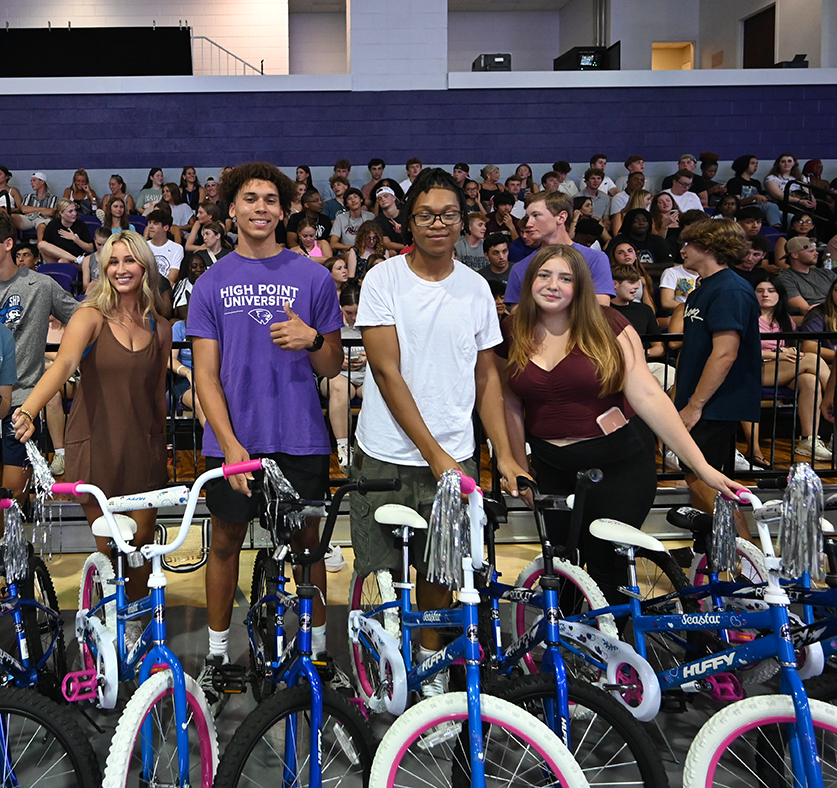 HPU freshmen smiled as they presented new bikes to local children. Pictured from left are Adrienne Brown from Belmont, Massachusetts; Kaleik Cook, from Olyphant, Pennsylvania; Darius Fuller, from Greensboro, North Carolina; and Tiffany Wineland, from Middlesex, New Jersey. 