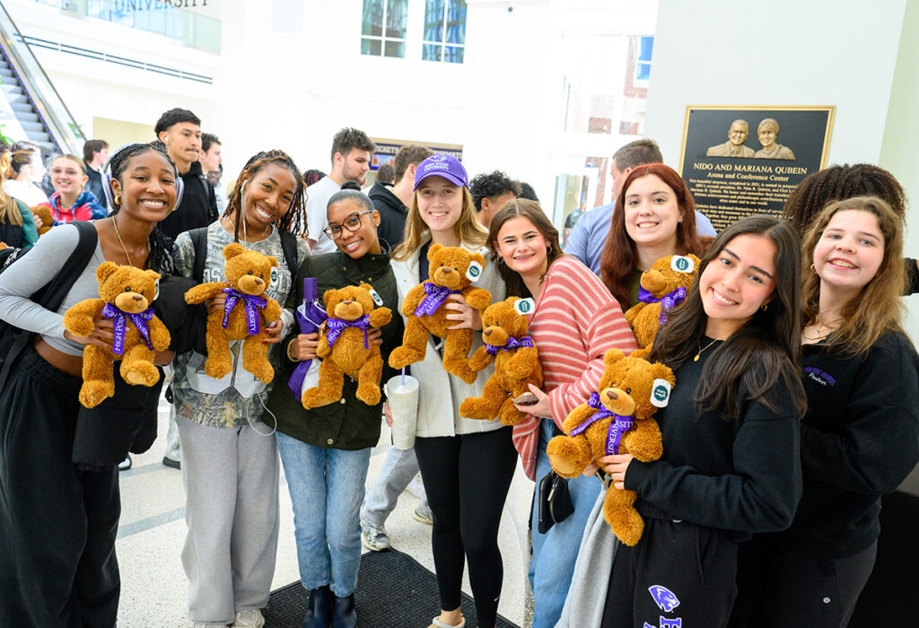 A group of freshmen smiled after they each received a teddy bear inside the Nido and Mariana Qubein Arena and Conference Center.