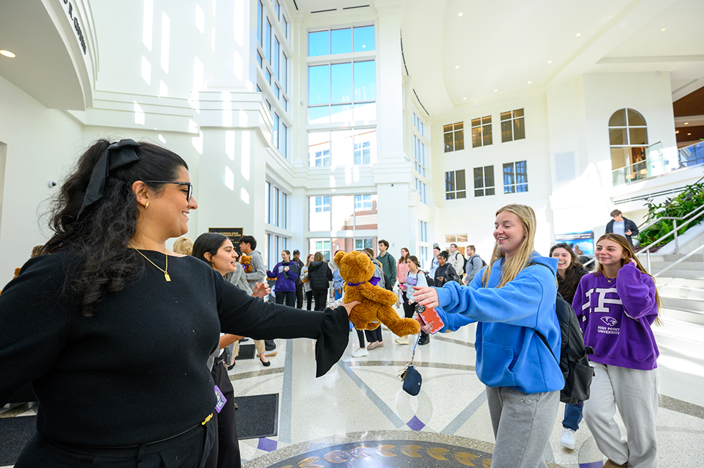 An HPU staff volunteer handed a student a teddy bear after her class.
