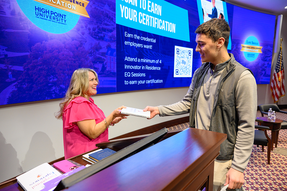 James handed a student a copy of her book, “Exceptional Experiences: Five Luxury Levers to Elevate Every Aspect of Your Business,” after her talk in the Callicutt Life Skills Theater.
