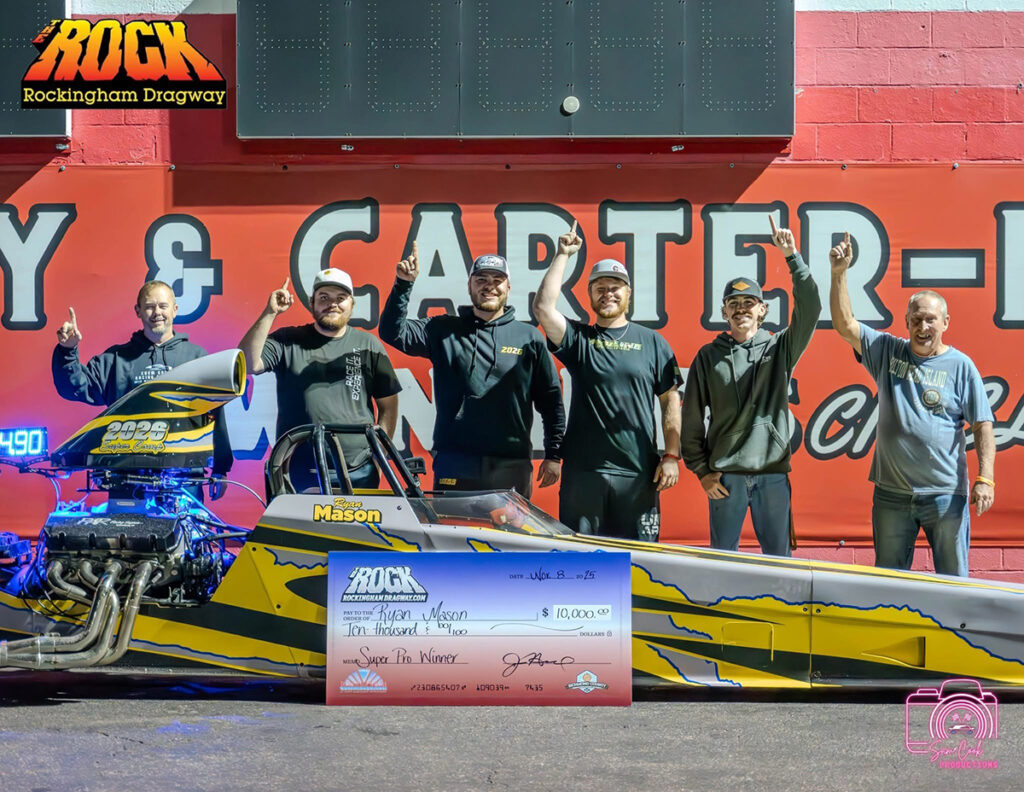 Mason is pictured at the center of his race team, wearing a black hoodie with 2026 on his chest.