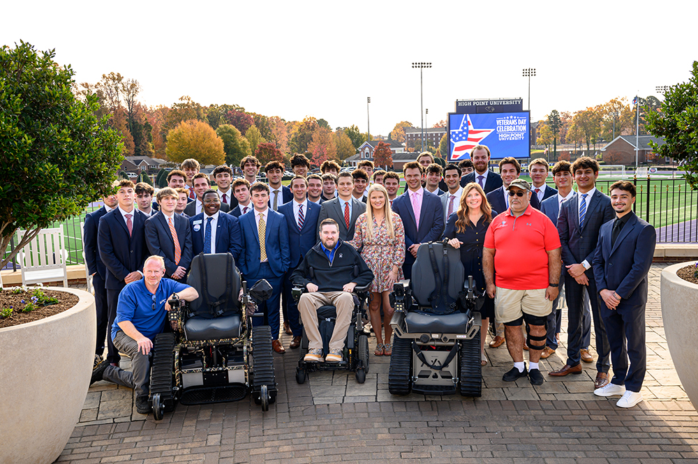 Tyler Nichols, who served in the U.S. Army airborne infantry, and his wife Emma Nichols, were pictured at center with members of HPU’s Kappa Alpha Order, which raised funds for Track Chairs to help improve mobility of critically injured veteran.