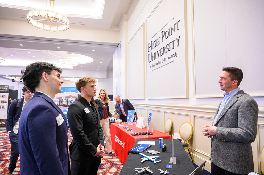 Jonathan Olik, a senior business administration major from Freehold, New Jersey, and Aidan Soto, a senior entrepreneurship major from Laudon, Virginia, talked with Christian Davies, a Boeing Company supply quality representative.