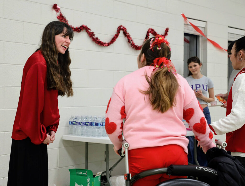Pictured at left, Ava Collins, a senior biology and graphic design major from Frederick, Maryland, interacted with a girl and her mother as Bella Berrios, a freshman elementary education major from Basking Ridge, New Jersey, stood by to give them water and snacks.