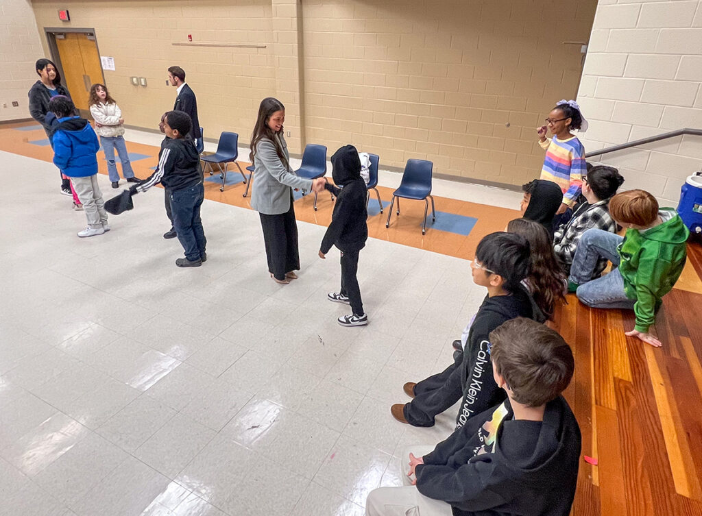 Seven HPU Professional Selling Club members introduced fifth-grade students to professional behaviors and courtesies through their First Impressions Project at Allen Jay Elementary School in High Point. Pictured at center was Ella Ott, a senior business administration major from High Point, greeting a fifth-grade student with a handshake.