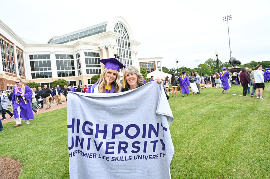 A new graduate and a family member held up an HPU blanket outside the arena. Every graduate received a blanket from the university to give to someone special in their lives who cared enough about them to sacrifice in support of that graduate’s higher education. 