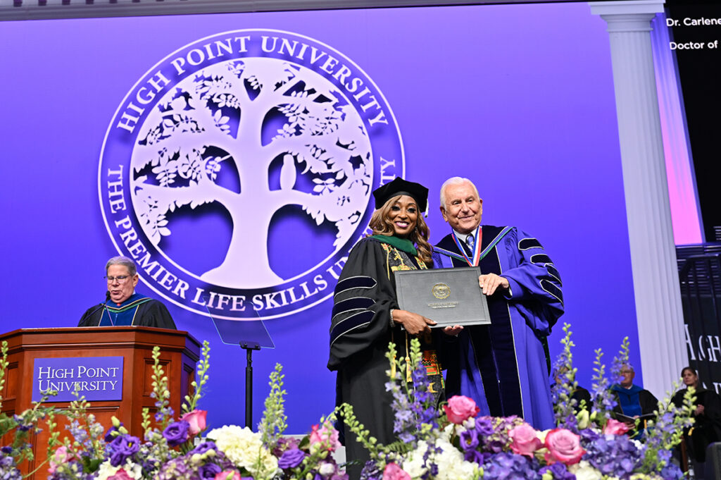 A graduate smiled as she paused on stage for a photo with Dr. Qubein. 