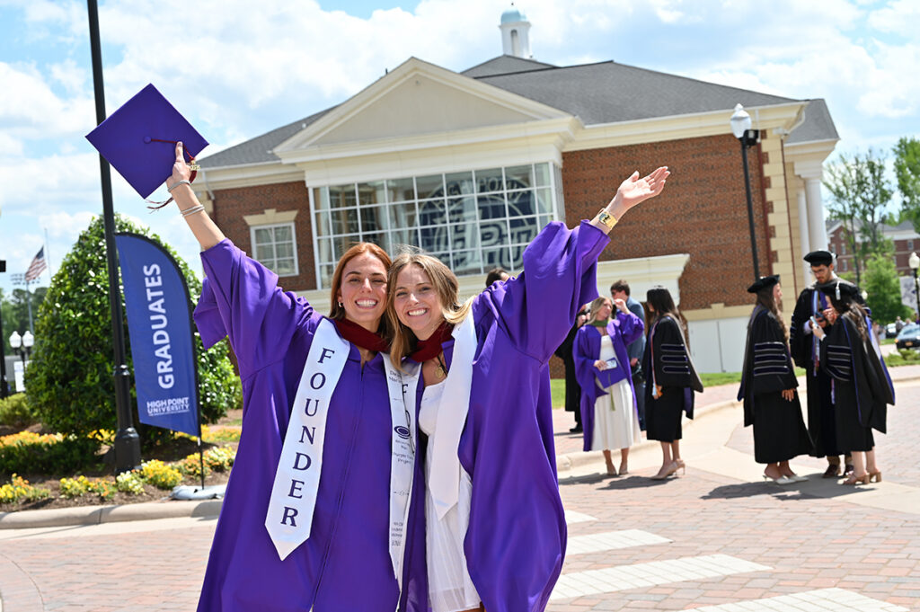 Two graduates celebrated outside the Nido and Mariana Qubein Arena and Conference Center.