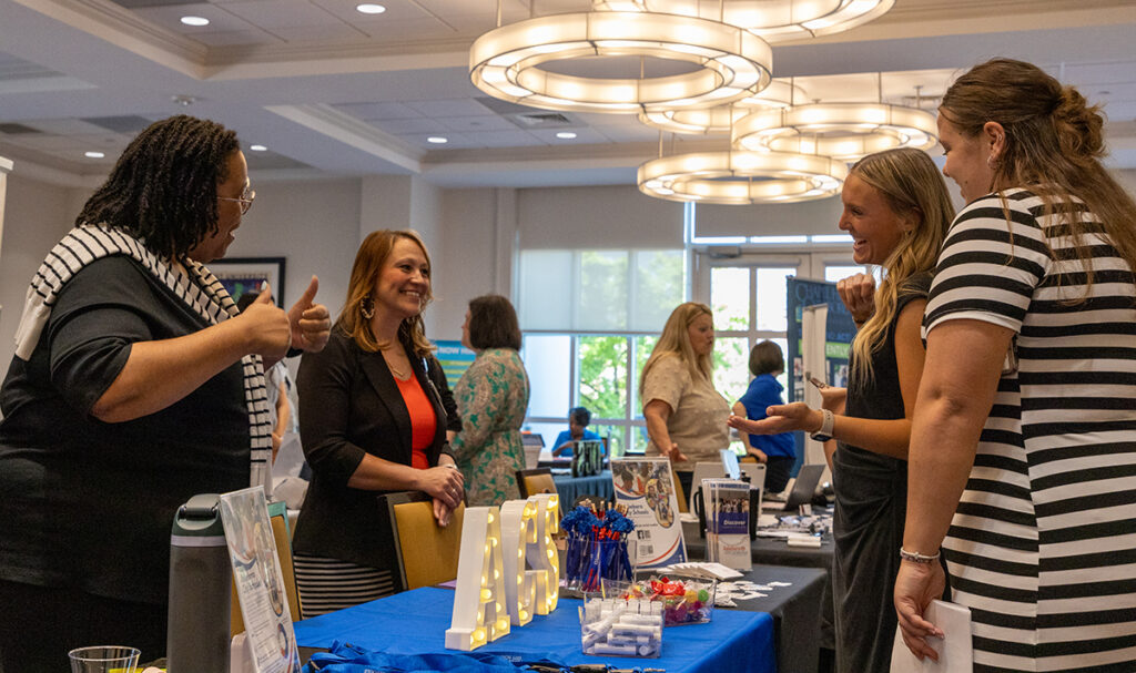 Recruiters from Alamance County Schools and HPU education students smiled as they talked during the career fair.
