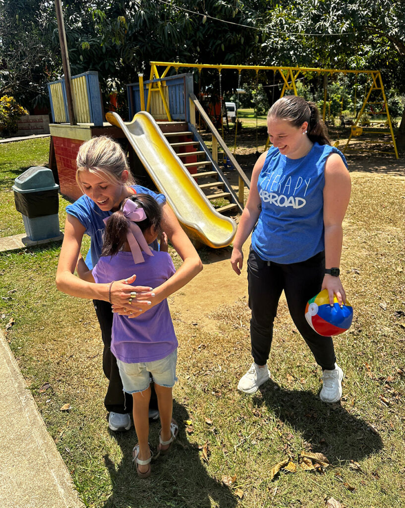 HPU Doctor of Physical Therapy student Noelle Spencer, left, provided a hug while Kloe Martin held a ball as they worked with a pediatric patient on therapeutic play.