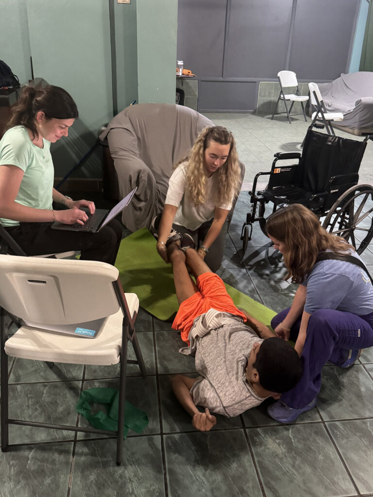HPU DPT students Kennedy Hazelwood, left, and Mackenzy Coltrain worked with a patient at a clinic in Belize along with Dr. Becca Medendorp, assistant professor and director of clinical education.