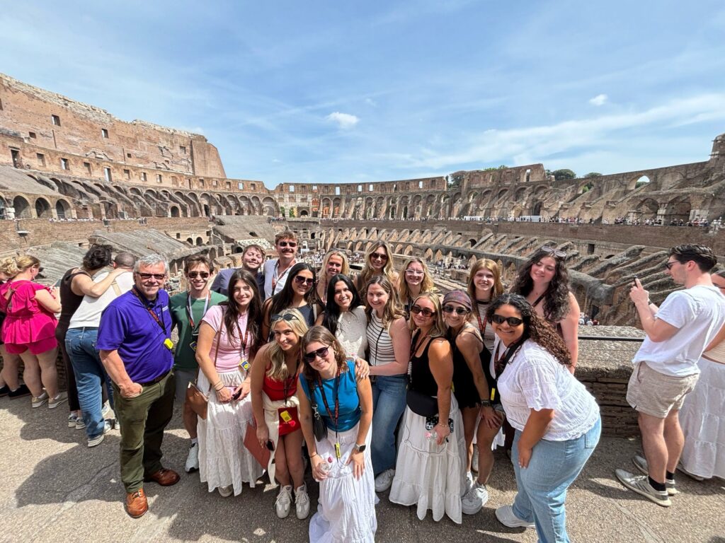 Dr. Brandon Lenoir, left, led a group visit to the Colosseum in Rome. He is an associate professor of political communication and helped lead the group of international strategic communications students through Italy.