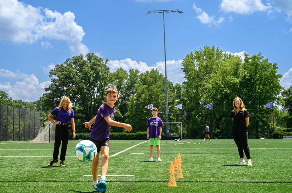 At left, Dr. Stacy Lipowski, associate professor of psychology, and Lily Grace Foister, a senior majoring in psychology as well as health and wellness, worked with two boys on soccer skills as they explored memory in children.