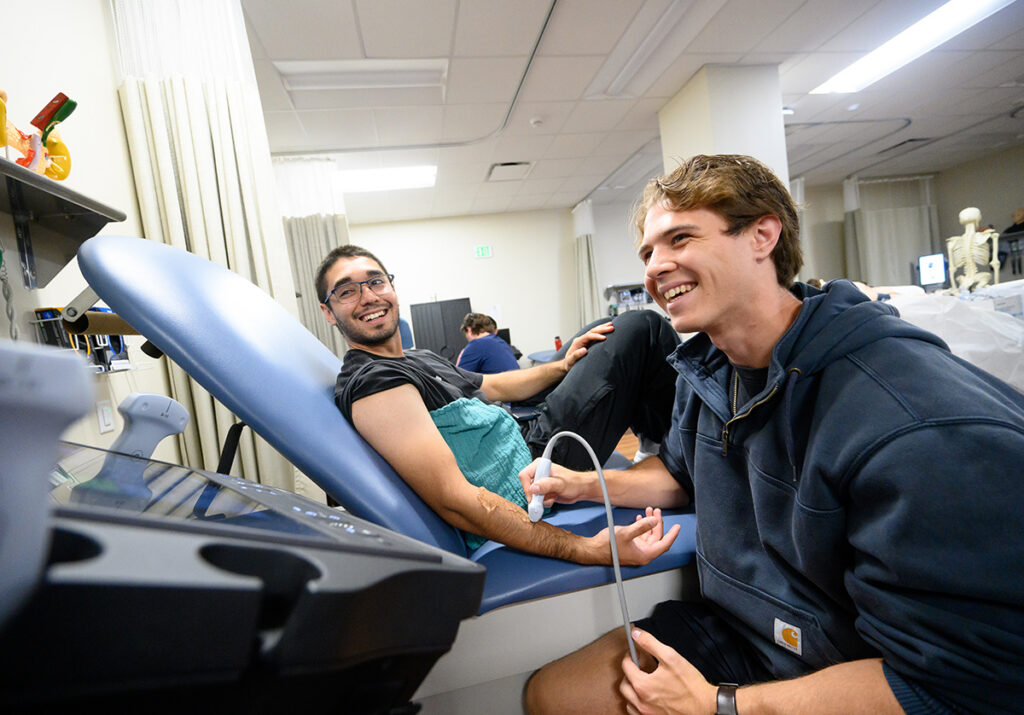 DPT students Jonathan Renteria-Rios, left, and Dylan Masalleras smiled during an ultrasound imaging training session.