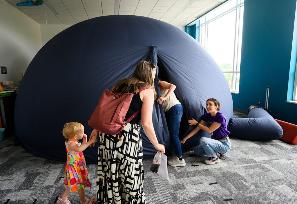 Culp Planetarium Director Erin Brady, right, welcomed parents and children into the mobile planetarium.