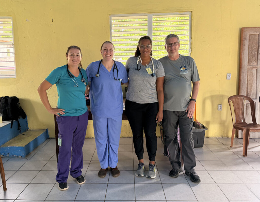 Ortiz Pate, left, with PA students Lauren Hyser, Clara Primus and Associate Professor Jeff Williams, outside a mobile clinic in Barranco, Belize.