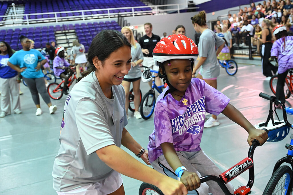 A HPU freshman helped a local child ride a new bike.