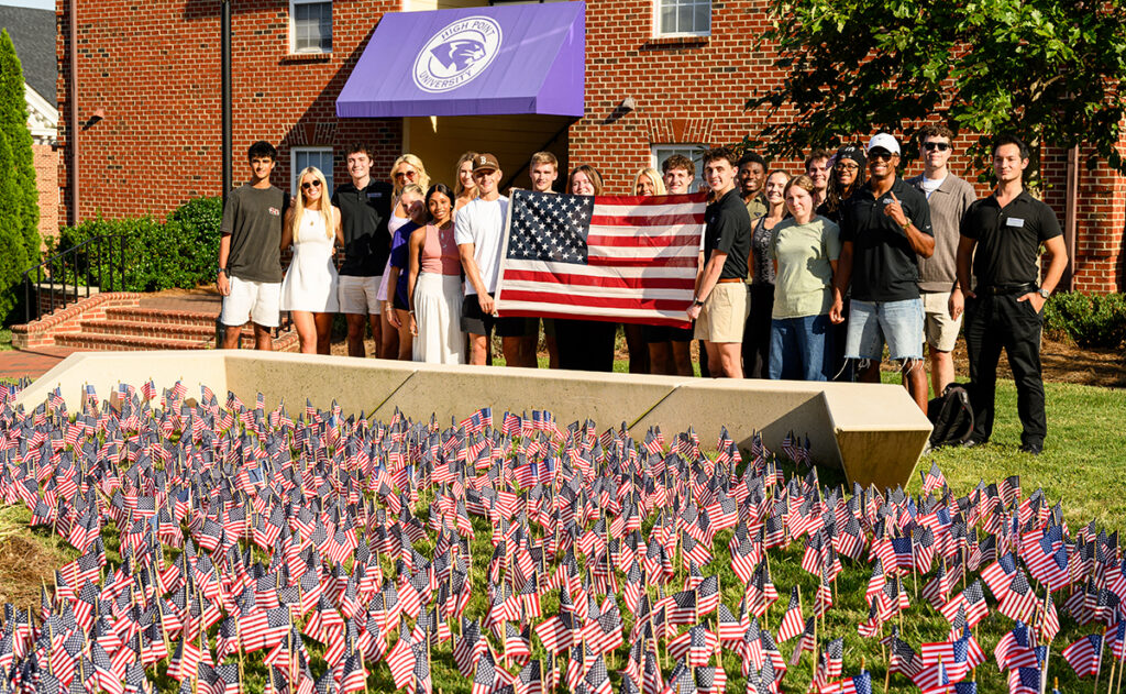 A group of students held a large flag after they planted smaller flags to honor each of the 2,977 lives lost on Sept. 11.