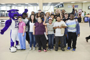 The photo features students and teachers from T.W. Andrews High School with the HPU Panther Prowler.