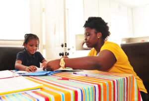 Junior Briayna Cuffie offers homework help to a 6-year-old student.