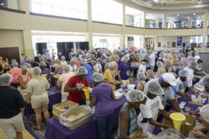 Students and their families package meals during a service projected organized by the Parent’s Council and Meals of Hope during Fall Family Weekend.