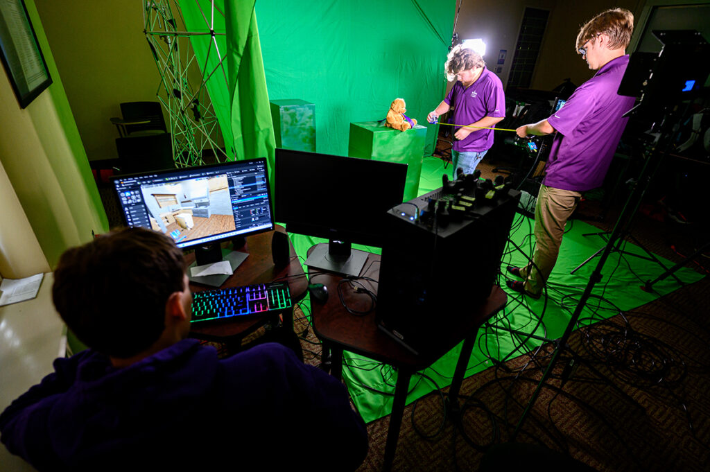 Game design and media production students are using a virtual production studio in the Nido R. Qubein School of Communication to produce a fire safety Public Service Announcement (PSA) that could be used for film and television. Pictured are students Austin Edwards, left, Shane Cooper, center, and Jacob Drew, setting up the virtual production studio.