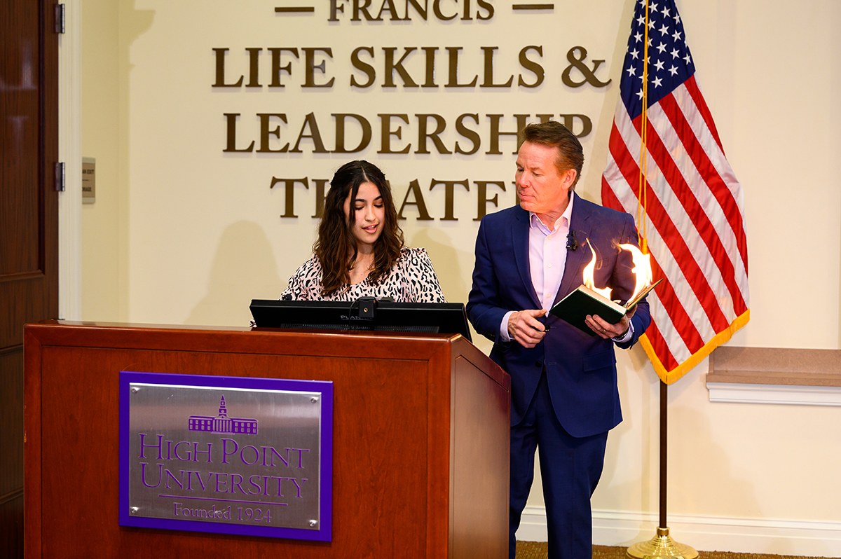 Pictured at left is Ashley Rodriguez, a freshman neurobiology major from Rockwall, Texas, who introduced Spangler, right, as his book bursts into flames. 